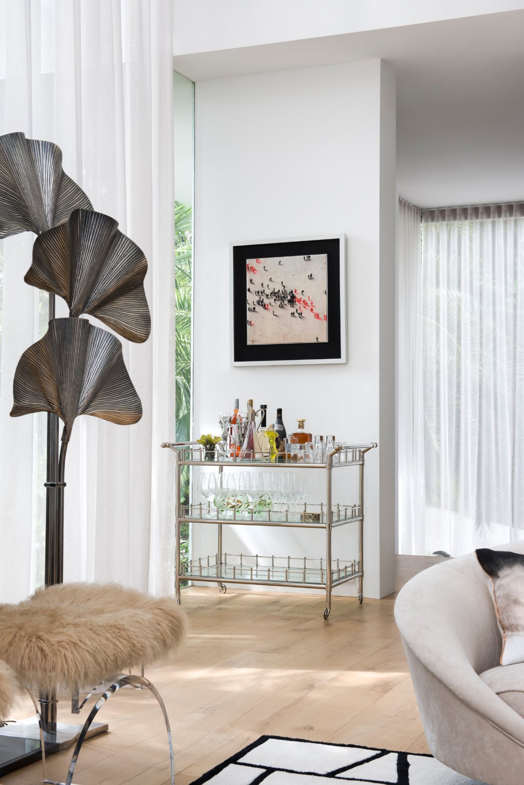 Eaglemont bar cart with bottles and glasses beside a sculptural floor lamp