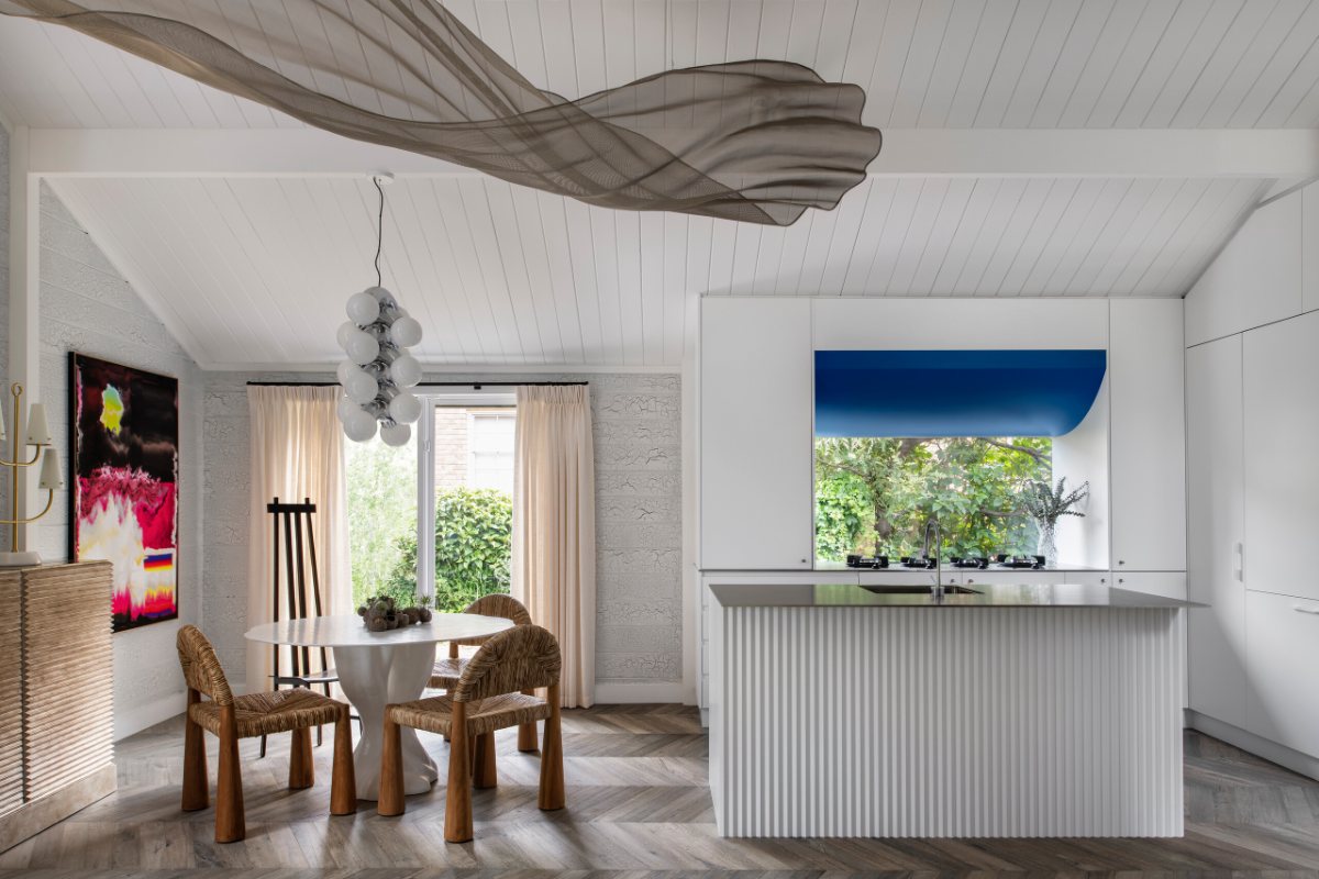 Mornington Beach House dining room and kitchen, with curtains at the window beside the table