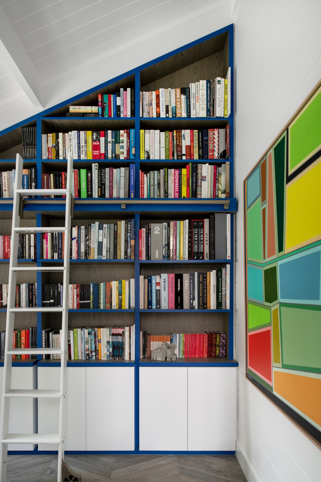Mornington Beach House library shelving with a ladder under a sloping ceiling